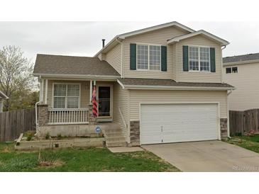 Charming two-story home featuring a front porch, two-car garage, and classic architectural details at 19524 Montview Dr, Aurora, CO 80011
