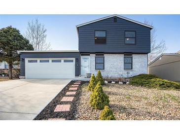 Charming home featuring a two-car garage, inviting brick walkway, and manicured landscaping at 17233 E Princeton Dr, Aurora, CO 80013