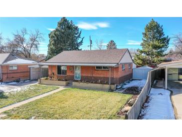 Charming brick home featuring a well-maintained lawn, covered porch, and convenient carport, perfect for curb appeal at 7081 Warren Dr, Denver, CO 80221
