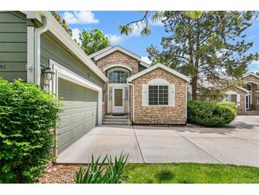 Charming home featuring stone accents, a well-manicured lawn, and an attached two-car garage at 7400 W Grant Ranch Blvd # 52, Littleton, CO 80123