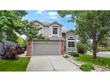 Charming two-story home with a well-manicured lawn, mature trees, and a spacious driveway leading to an attached garage at 11301 Vernon Way, Parker, CO 80134