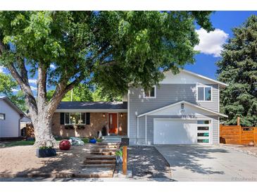 Charming home with a mix of brick and siding, mature trees, a front yard, and an attached two car garage at 2117 S Balsam Ct, Lakewood, CO 80227