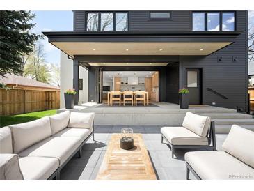 Relaxing outdoor patio with comfortable seating and views to the home's open kitchen and dining area at 1462 S Vine St, Denver, CO 80210