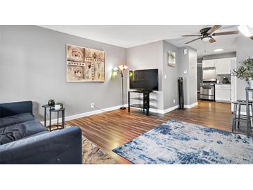 Living room includes a comfy couch, large TV, and wood-look floors at 63 S Sable Blvd # 16, Aurora, CO 80012