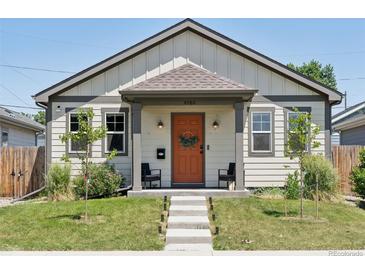 Charming home with a welcoming orange front door and a well-manicured lawn at 4080 Adams St, Denver, CO 80216