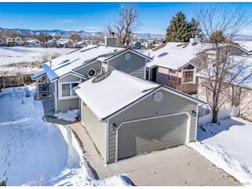 Exterior of house with snow covered yard and mountain views at 9485 Joyce Ln, Highlands Ranch, CO 80126