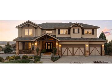 Two-story house with stone accents, three car garage, and landscaping at 1365 Gentry Pl, Castle Rock, CO 80104