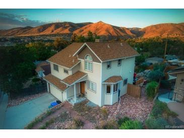Inviting two-story home featuring a well-maintained lawn and mountain views at 420 Sunshine Pkwy, Golden, CO 80403