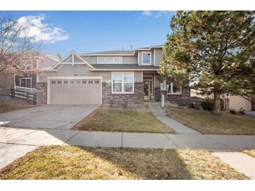 Charming two-story home with a well-manicured lawn, brick accents, and an attached two-car garage at 6483 S Irvington Way, Aurora, CO 80016