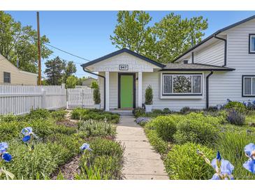 Charming home with a landscaped front yard, white picket fence, and a bright green front door at 947 S Yates St, Denver, CO 80219