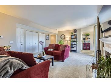 Inviting living room with plush red sofas and neutral carpet at 7665 E Eastman Ave # 210, Denver, CO 80231