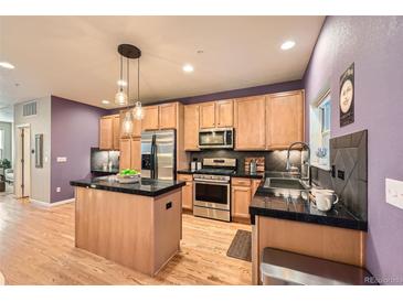 Bright kitchen featuring stainless steel appliances, hardwood floors, and a modern island at 453 S Quay Street, Lakewood, CO 80226