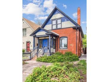 Charming two-story brick home with blue accents, a covered porch, and a well-maintained front yard at 434 N Washington St, Denver, CO 80203