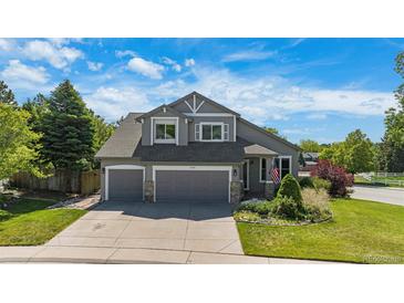 Charming two-story home with a well-manicured lawn and a two-car garage at 7696 S Hudson Way, Centennial, CO 80122