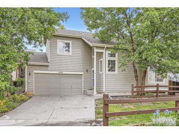 Charming home featuring a two-car garage, light colored siding, and mature trees at 11029 Grouse Ct, Parker, CO 80134