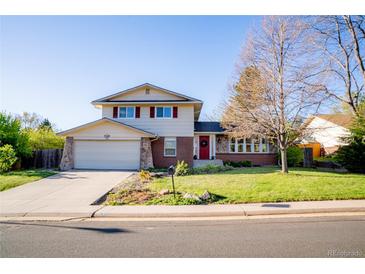Charming two-story home featuring a well-manicured lawn and a welcoming red front door at 7328 S Kit Carson St, Centennial, CO 80122