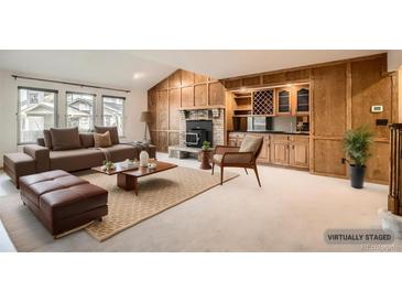 Staged living room with a wooden fireplace and built-in bar area at 6141 W Evans Pl, Lakewood, CO 80227