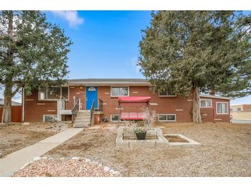Brick ranch home with landscaped yard and inviting front porch at 2095 Newland St, Edgewater, CO 80214