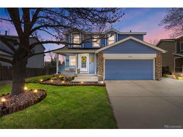 Charming two-story home with a well-manicured lawn, stone accents, and a cozy front porch at 11753 Elizabeth Cir, Thornton, CO 80233