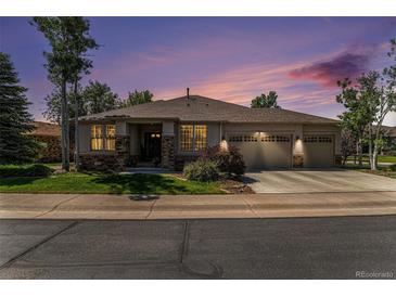 Charming single-story home with a three-car garage and stone accents set against a vibrant sunset sky at 11422 W Cooper Ave, Littleton, CO 80127