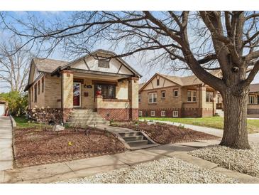 Charming brick bungalow with landscaped front yard and inviting front porch at 1454 Utica St, Denver, CO 80204