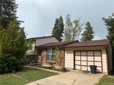Charming home with a brick facade, a well-manicured lawn, and an attached garage at 9260 Cody Ln, Broomfield, CO 80021