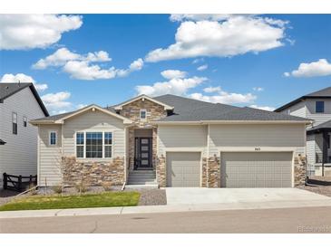 Charming home featuring stone accents, a three-car garage, and professionally landscaped front yard at 863 Edenborn Pl, Castle Rock, CO 80104