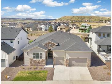 Beautiful single-Gathering home with stone accents, three-car garage, and mountain views at 863 Edenborn Pl, Castle Rock, CO 80104