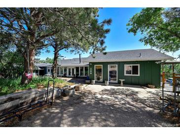 Charming single story exterior featuring a spacious parking area, lush trees, and beautiful landscaping at 4380 Sandstone Dr, Monument, CO 80132