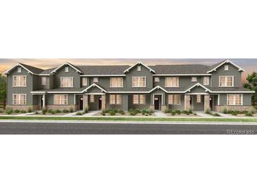 Modern townhome featuring stone accents, sleek lines, and a welcoming entrance at 17115 W 91St Ln, Arvada, CO 80007
