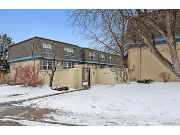 Beautiful condominium complex with landscaped grounds and secure access in a snowy environment at 9250 E Girard Ave # 10, Denver, CO 80231