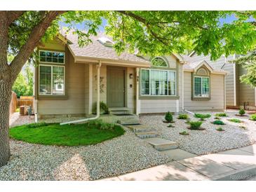 A charming exterior view of a well-maintained home with front yard landscaping and mature trees at 98 N Quicksilver Ave, Castle Rock, CO 80104