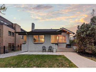 Charming single-story home featuring a well-manicured lawn and inviting front patio at 561 Cook St, Denver, CO 80206