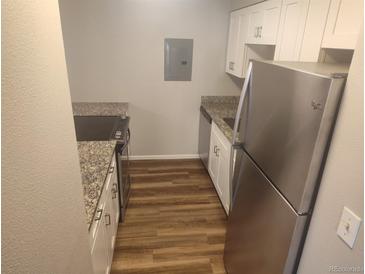 Cozy kitchen featuring granite counters, stainless steel appliances, and wood flooring at 12148 Melody Dr # 108, Denver, CO 80234