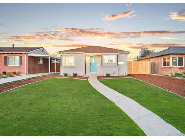 Charming single-story home boasts a well-manicured lawn and inviting blue front door at 3630 Magnolia St, Denver, CO 80207