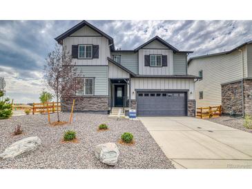 Beautiful two-story home featuring stone accents, gray siding, a two-car garage and a manicured front yard at 2197 S Jackson Gap St, Aurora, CO 80018