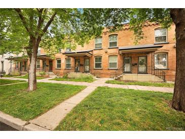 Charming brick townhomes featuring neat front lawns and inviting entrances at 709 27Th St, Denver, CO 80205