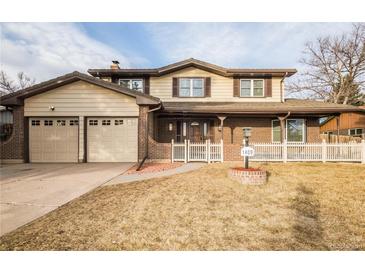 Charming two-story home featuring a two-car garage, brick accents, and a well-maintained front yard at 1409 S Moline St, Aurora, CO 80012