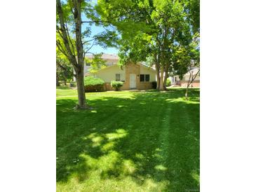 Charming home with a well-maintained lawn, mature trees and a welcoming front entrance at 9105 E Lehigh Ave # 105, Denver, CO 80237