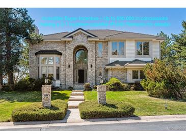 Inviting two-story brick home featuring manicured lawn and arched entry, enhancing curb appeal at 72 Falcon Hills Dr, Highlands Ranch, CO 80126