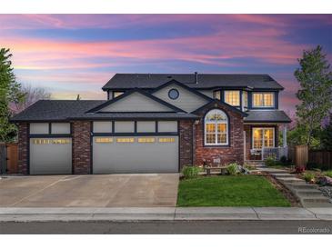 Charming two-story brick home with a three car garage, manicured lawn and beautiful landscaping under a gorgeous sunset at 1300 W 13Th Ave, Broomfield, CO 80020