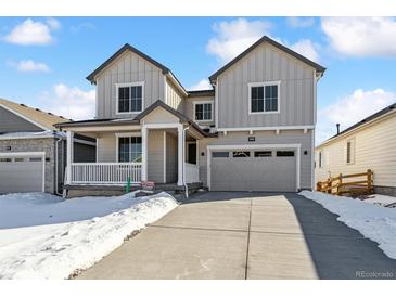 Two-story home with gray siding, a large driveway, and a front porch at 674 Penn Rd, Elizabeth, CO 80107