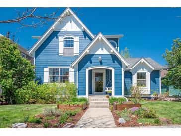 Charming blue two-story home with white trim, manicured landscaping and inviting entrance at 3171 Fulton St, Denver, CO 80238
