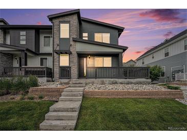 Contemporary two-story home featuring stone accents, a front porch, and well-maintained landscaping at 2054 S Upham Way, Denver, CO 80227