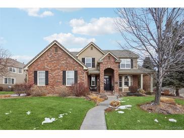 Charming brick home featuring a manicured lawn, a walkway to the front door, and classic architectural details at 19113 E Fair Dr, Aurora, CO 80016