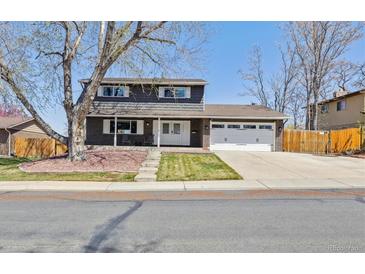 Charming two-story home with a brick and grey facade, mature tree, and well-maintained front yard at 9290 N Raleigh St, Westminster, CO 80031