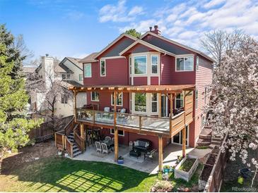 Two story home with a spacious deck, outdoor seating, and backyard at 9145 Sugarstone Cir, Highlands Ranch, CO 80130