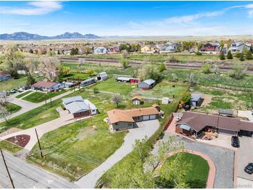 Expansive property showcases a ranch-style home with barns, outbuildings, and mountain views at 13805 W 82Nd Ave, Arvada, CO 80005