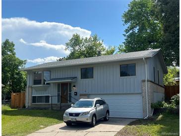 Charming two-story home with attached garage and manicured front yard with car parked in driveway at 1477 S Wright Ct, Lakewood, CO 80228