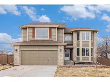 Charming two-story home features a brick-accented facade, attached garage, and a well-manicured front yard at 6876 Edgewood Way, Highlands Ranch, CO 80130